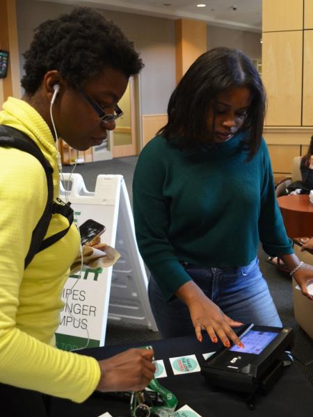 Two individuals gathering meal swipes for the Swipe Out Hunger Program.
